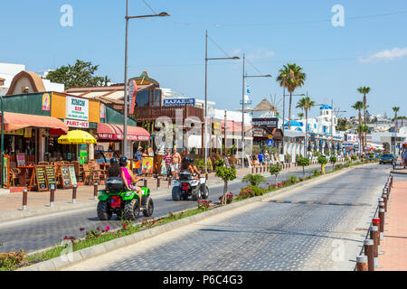 Straßenszene in Ayia Napa Stadt, mit Touristen reiten auf 4x4 sand Kinderwagen, Ayia Napa, Zypern Stockfoto