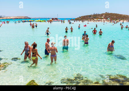 Urlauber schwimmen im Meer bei Nissi Bay, Nissi Beach, in der Nähe von Ayia Napa, Zypern Stockfoto