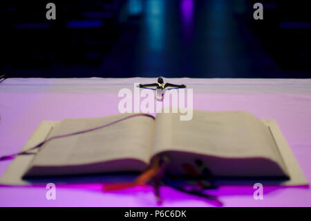 Kreuz hinter einem Buch, das auf dem Altar am Kreuz konzentrierte sich der Rest defokussierten Stockfoto