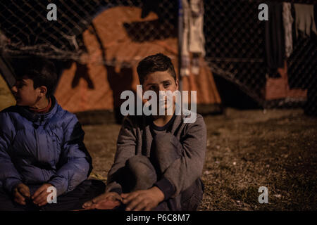 Flüchtling versuchen sich durch ein Feuer in der Nacht zu warm am provisorischen Flüchtlingslager der Greek-Macedonian Grenze in der Nähe des griechischen Dorf Idome Stockfoto