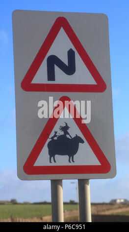 Eine roadsie Zeichen, dass von einem graffit Künstler ein Schaf mit einer Hexe und schwarze Katze auf der Schafe zurück zu zeigen angepasst wurde. Stockfoto