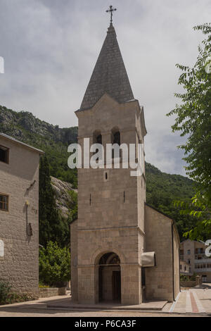 Vorderansicht der serbisch-orthodoxen Kirche der Heiligen Dreifaltigkeit am unteren Kloster Ostrog, Danilovgrad, Montenegro, der Glockenturm und Eingang. Stockfoto