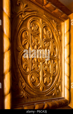 Aufwändig geschnitzte dekorative Holz- Türhaut vorne an der serbisch-orthodoxen Kirche der Heiligen Dreifaltigkeit am unteren Kloster Ostrog, Danilovgrad, Montenegro. Stockfoto