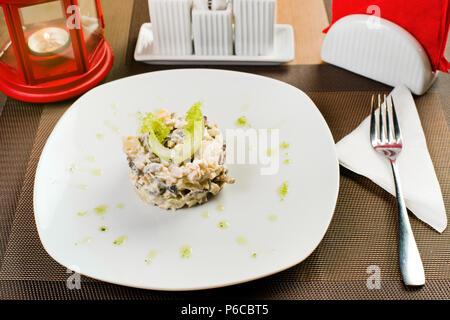 Keramik weiße Platte mit Salat, am Tisch im Restaurant Stockfoto