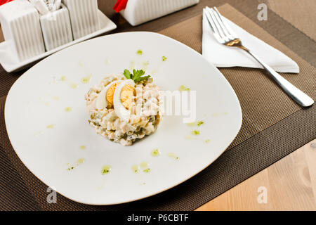 Keramik weiße Platte mit Salat, am Tisch im Restaurant Stockfoto