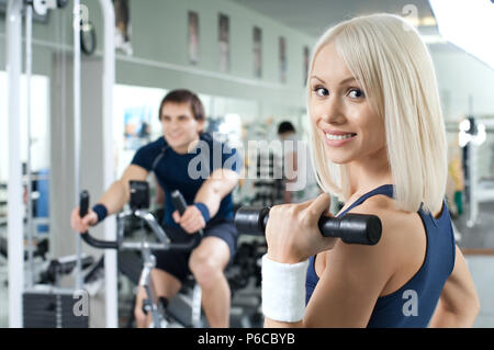 Happy cutie sportliche Mädchen, Übung mit Hanteln und Lächeln, im Sport - Halle Stockfoto