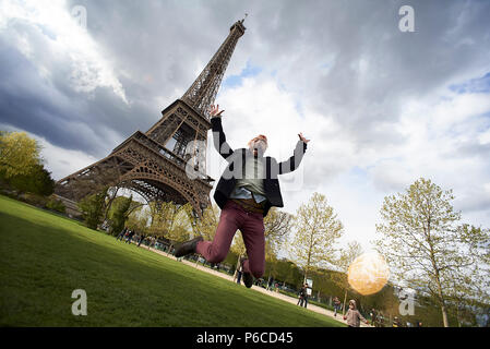 Verrückten spaß Schoß eines jungen Mannes glücklich und aufgeregt sprang hoch in die Luft vor dem Eiffelturm in Paris. Stockfoto