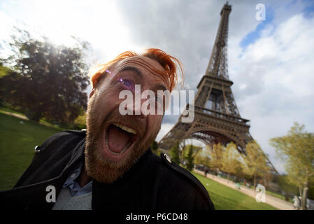 Verrückten spaß Schoß eines jungen Mannes glücklich und aufgeregt sprang hoch in die Luft vor dem Eiffelturm in Paris. Stockfoto