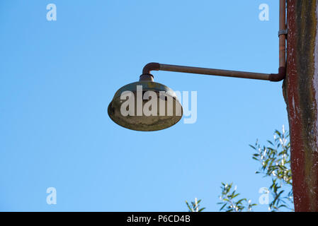 Eine alte, nicht mehr verwendete Straßen- oder Wegleuchte ohne Globus, die an einem hölzerne Strommast in Australien befestigt ist Stockfoto