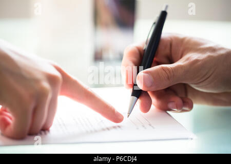 Nahaufnahme der Unternehmer Hand Unterstützung der Mitarbeiter beim Signieren Dokument Stockfoto