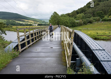 Ein Radfahrer kreuzt die alte Eisenbahnbrücke auf SUSTRANS cycle Route 1 Innerleithen, Scottish Borders, in der Nähe von Edimburgh Stockfoto