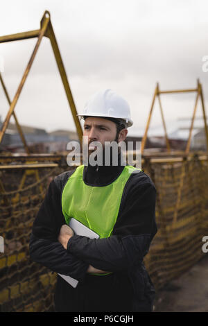 Arbeitnehmer stehen mit der Waffe in der Werft gekreuzt Dock Stockfoto