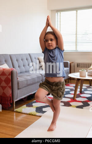 Kleines Mädchen mit Yoga im Wohnzimmer Stockfoto