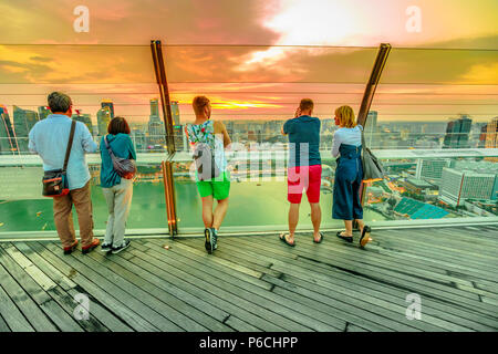 Singapur - Mai 3, 2018: Touristen, Panoramablick von der Aussichtsplattform Skypark von Marina Bay Sands Hotel und Casino. Bankenviertel Skyline im Hintergrund. Sonnenuntergang geschossen. Stockfoto