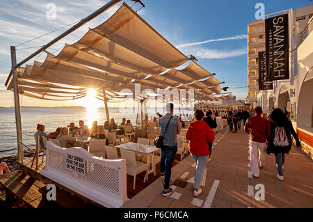 Insel Ibiza, Spanien - 1. Mai 2018: Menschenmassen, den Sonnenuntergang von der Terrasse am Meer von Savannah Café Treffen, an der Westküste von Ibiza. Diese Stockfoto