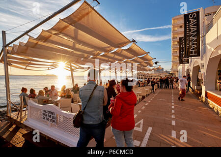 Insel Ibiza, Spanien - 1. Mai 2018: Menschenmassen, den Sonnenuntergang von der Terrasse am Meer von Savannah Café Treffen, an der Westküste von Ibiza. Diese Stockfoto