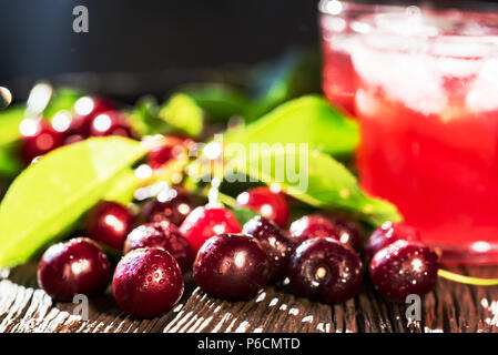 Frische Kirschen und Eis kirsche frucht Getränk auf Holz Stockfoto