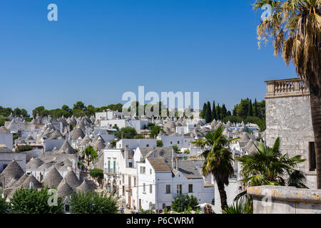 Schöne Stadt Alberobello mit Trulli unter grünen Pflanzen und Blumen, wichtigsten touristischen Bezirk, Region Apulien, Süditalien Stockfoto