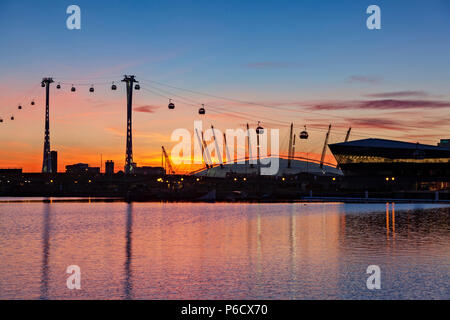 Blick auf den Sonnenuntergang vom Royal Victoria Dock mit der Londoner City Hall, die früher Crystal genannt wurde, und der Arena von O2 und dem Emirates Flyer. Stockfoto