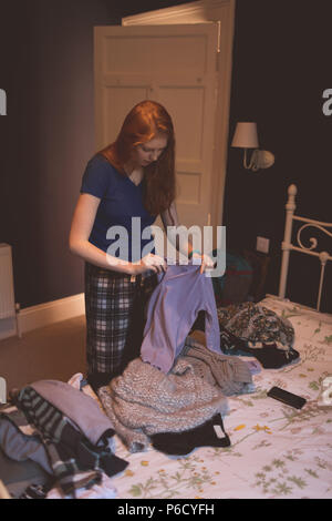 Frau Falten Kleidung im Schlafzimmer Stockfoto