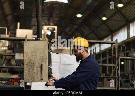Techniker überprüfen Maschine in Fabrik Stockfoto