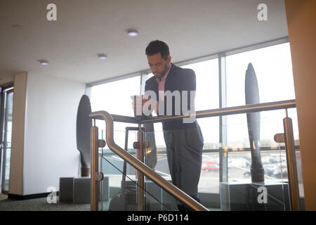 Geschäftsmann mit Mobiltelefon im Korridor Stockfoto