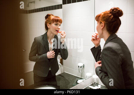 Geschäftsfrau Anwendung Lippenstift in Bad Stockfoto