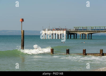 Boscombe Pier an einem sonnigen Sommertag mit einer Menge von Menschen snading am Ende, Bournemouth, Dorset, Großbritannien Stockfoto