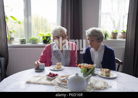 Ältere Freunde Interaktion Hexe einander beim Frühstück Stockfoto