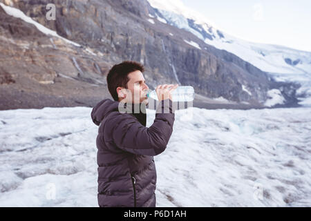 Man Trinkwasser aus der Flasche Wasser Stockfoto