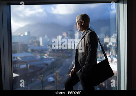 Business Mann, draußen vor dem Fenster Stockfoto