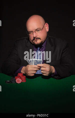 Card Player im Geschäft. Gläser und Krawatte mit Spielmarken auf schwarzem Hintergrund. Stockfoto
