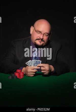 Card Player im Geschäft. Gläser und Krawatte mit Spielmarken auf schwarzem Hintergrund. Stockfoto