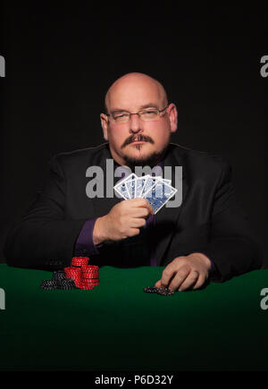 Card Player im Geschäft. Gläser und Krawatte mit Spielmarken auf schwarzem Hintergrund. Stockfoto