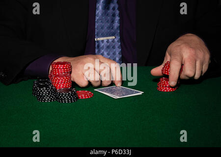 Card Player im Geschäft. Gläser und Krawatte mit Spielmarken auf schwarzem Hintergrund. Stockfoto