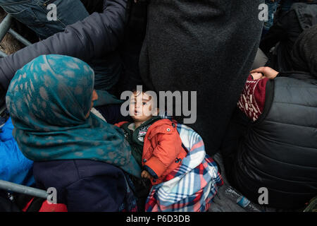 Ein flüchtling Mutter hält Ihr Kind, während sie wartet, in der Nähe der Grenze Tor der Grenze am provisorischen Flüchtlingslager der Greek-Macedonian borde zu überqueren Stockfoto