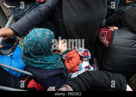 Ein flüchtling Mutter hält Ihr Kind, während sie wartet, in der Nähe der Grenze Tor der Grenze am provisorischen Flüchtlingslager der Greek-Macedonian borde zu überqueren Stockfoto