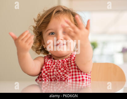 Schöne blonde Kind lächelnd Fragen für Halten, wollen Aufmerksamkeit zu Hause. Stockfoto