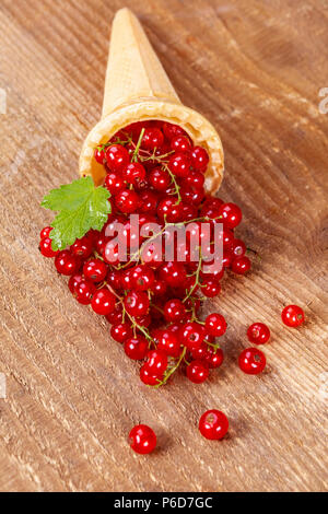 Rote Johannisbeere Früchte in Eis auf hölzernen Tisch. Fokus auf rote Johannisbeere. Stockfoto