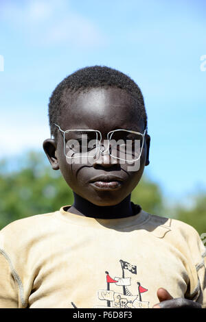 UGANDA, Karamoja, Kaabong, Dorf Lochom, Karamojong Stamm, Junge mit Kabel Spezifikationen/Junge mit Drahtbrille Stockfoto