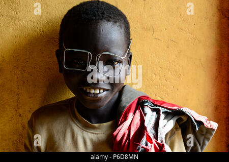 UGANDA, Karamoja, Kaabong, Dorf Lochom, Karamojong Stamm, Junge mit Kabel Spezifikationen/Junge mit Drahtbrille Stockfoto