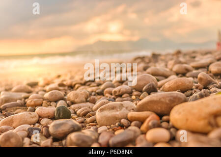 Nasse Steine am Strand meer sommer Ufer Horizont mit Bergen und Märchen weichen Farben Wolken über. Tyhrrenian Meer, Salerno, Italien Stockfoto