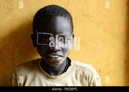 UGANDA, Karamoja, Kaabong, Dorf Lochom, Karamojong Stamm, Junge mit Kabel Spezifikationen/Junge mit Drahtbrille Stockfoto