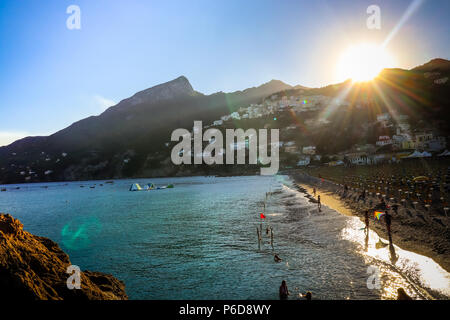 Vietri sul Mare Sommer am Strand Sonnenuntergang über den Bergen mit Menschen und bunte Drachen in der Nähe von Tyhrrenian Meer. Küste von Amalfi. Südlich von Italien Stockfoto