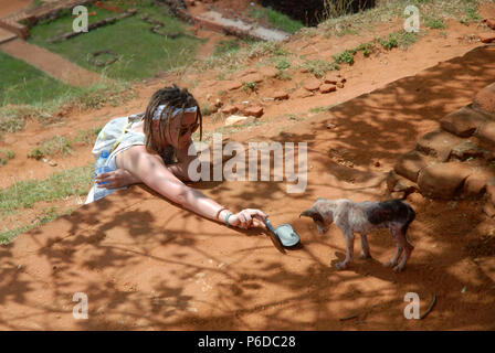 Lady Fütterung verirrte Hund, Sigiriya Rock Fortress, Sigiriya, Central Province, Sri Lanka. Stockfoto