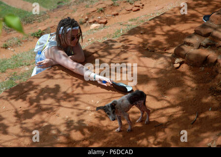 Lady Fütterung verirrte Hund, Sigiriya Rock Fortress, Sigiriya, Central Province, Sri Lanka. Stockfoto