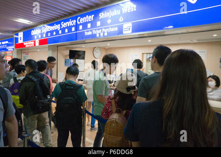 Leute anstellen an der Odakyu Eisenbahn Sightseeing Service center Fahrkarten nach Hakone und Enoshima, Shinjuku, Tokyo Japan zu Kaufen Stockfoto