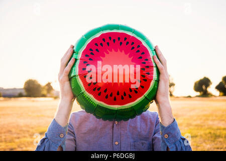 Ein Mann hält eine Wassermelone Ballon über sein Gesicht, Sommerzeit Konzept Stockfoto