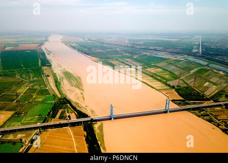 Jinan. 24. Juni, 2018. Luftbild von am Juni 24, 2018 zeigt die Shengli Yellow River Brücke im Stadtteil Kenli Dongying, im Osten der chinesischen Provinz Shandong. Der gelbe Fluss, der zweitlängste Fluss in China, verursacht auf dem Qinghai-Tibet Plateau und mündet in der bohai Meer aus Dongying Stadt. Die Stadt ist bemüht, ökologische Zivilisation zu fördern und den Bau von "Feuchtgebiet Stadt" beschleunigen. Credit: Zhu Zheng/Xinhua/Alamy leben Nachrichten Stockfoto