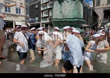 Kopenhagen, Dänemark. Juni 29, 2018. Glücklich, dänische Schüler feiern ihre High School, Gymnasium Abschluss und nehmen den Sprung. Ein Tanz und ein Sprung in das kalte Wasser des Storchbrunnens (Storkespringvandet) in der Fußgängerzone Stroeget ist ein traditionelles Element am Tag der Feier für Studenten im Großraum Kopenhagen. Es ist oft Teil der langen, anstrengenden und temperamentvollen LKW-Tour, die jedes Studenten zu Hause für Erfrischungen besucht. Kredit: Niels Quist/Alamy Live Nachrichten Stockfoto